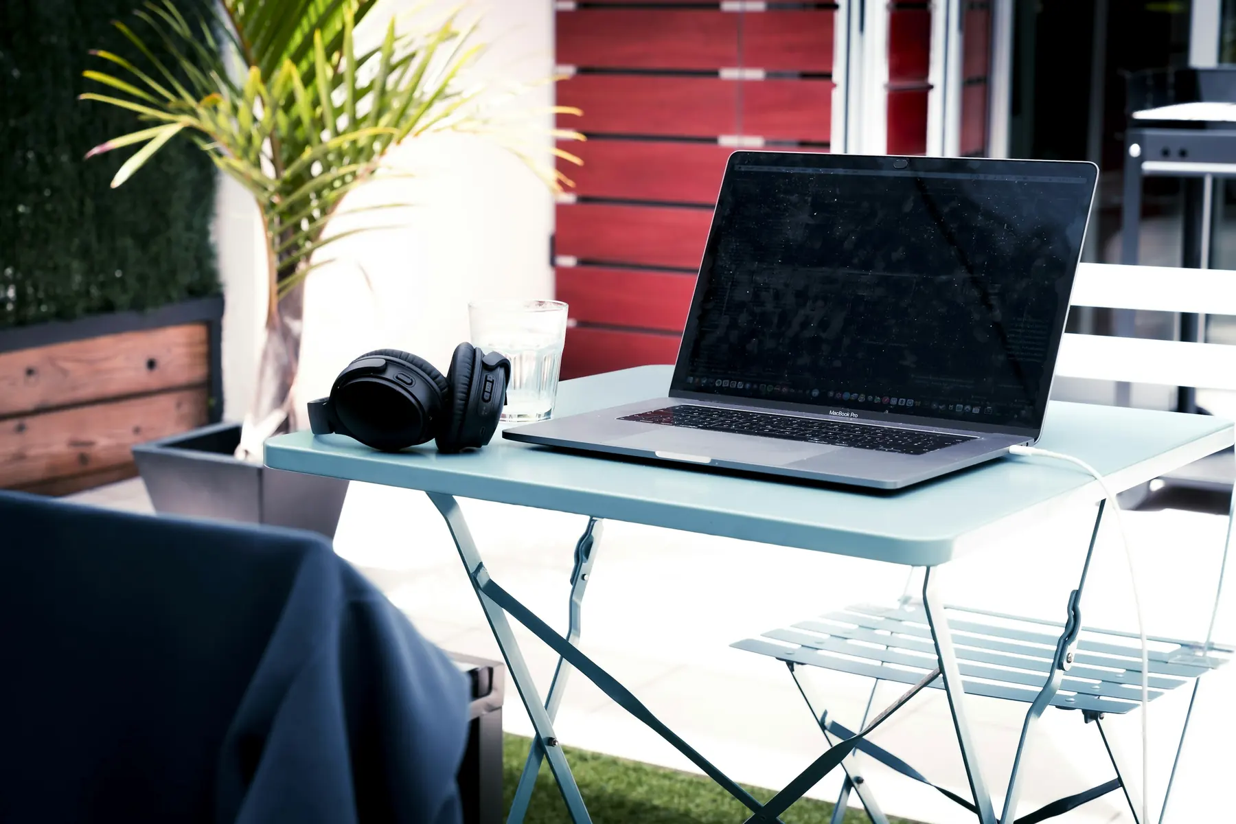 Laptop on a small table on a sunny balcony